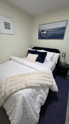 a bedroom with two beds with white sheets and a blue rug at Home Away From Home With Free Netflix, Prime and Paramount in Calgary
