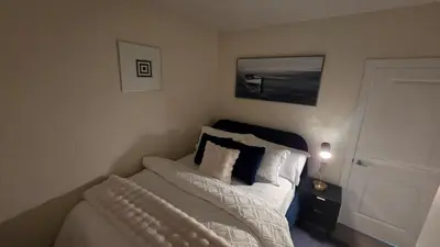 a small bedroom with a bed with pillows at Home Away From Home With Free Netflix, Prime and Paramount in Calgary