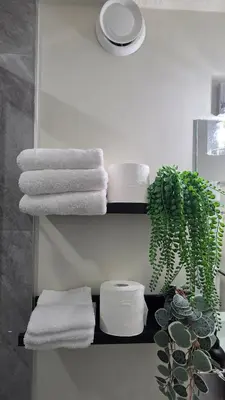 a towel rack with towels and a plant in a bathroom at Home Away From Home With Free Netflix, Prime and Paramount in Calgary