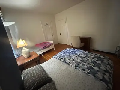a bedroom with a bed and a table with a lamp at Vancouver Home - Airport 10 Min, Downtown 15 Min - Free Parking & Fast Wi-Fi in Vancouver