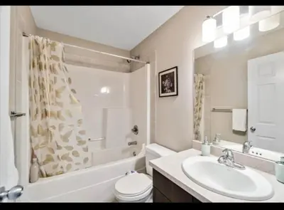 a bathroom with a sink and a toilet and a tub at Entertainment house with 2 king 1 queen 1 sofa bed In-house Theater Attach Garage Near YEG Loved by Guests on Other Plateform in Edmonton