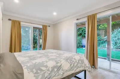 a bedroom with a bed and large windows at Spacious Oceanview Suite with Private Entrance in West Vancouver
