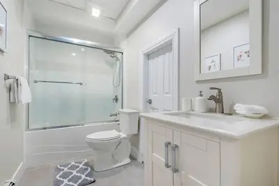 a white bathroom with a toilet and a shower at Spacious Oceanview Suite with Private Entrance in West Vancouver