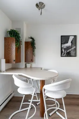 a white table and four white chairs in a room at Unit 33 - 4 bedrooms - Sleeps 10 in Bélanger