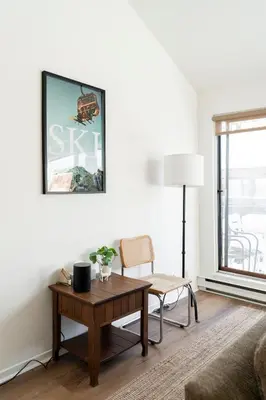a living room with a table and a chair at Unit 33 - 4 bedrooms - Sleeps 10 in Bélanger