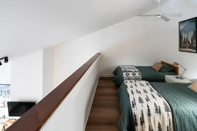a attic bedroom with a bed and a staircase at Unit 33 - 4 bedrooms - Sleeps 10 in Bélanger