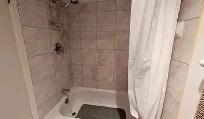 a bathroom with a shower with a white shower curtain at Unit 33 - 4 bedrooms - Sleeps 10 in Bélanger