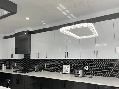 a kitchen with white cabinets and a chandelier at Private room with full washroom in Edmonton