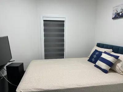 a white bedroom with a bed with blue accents at Private room with full washroom in Edmonton