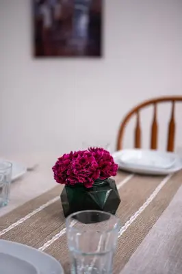 a vase of purple flowers sitting on a table at Cozy 2B Suite in Great Location Near Trails & Shop in North Vancouver