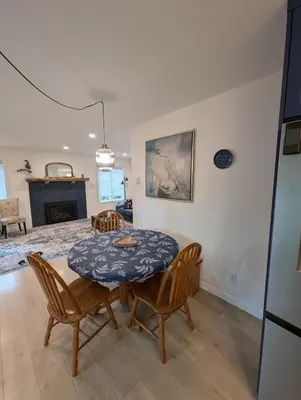 a dining room with a table and chairs and a fireplace at Colwood Hidden Home in Colwood