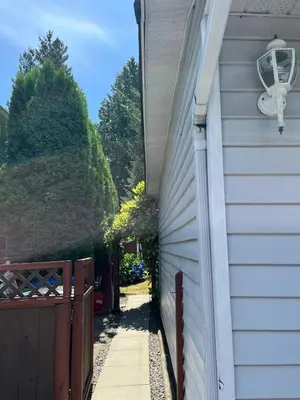 a side view of a fence next to a house at Surrey Home - King George Blvd & Rapid Transit - Airport 25 Min - Free Parking & Wi-Fi in Surrey