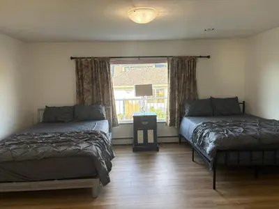 a bedroom with two beds and a window at Vancouver Guest House - Airport & Downtown 15 Min - Free Parking & Fast Wi-Fi in Vancouver