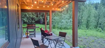 a patio with a table and chairs and a grill at Luxury 1BR at Red Mountain Ski-Bike Sauna in Rossland
