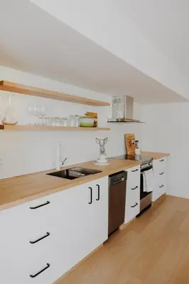 a kitchen with white cabinets and a wooden counter top at Luxury 1BR at Red Mountain Ski-Bike Sauna in Rossland
