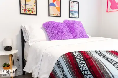 a bedroom with a purple pillow on a bed at The Neon Palace - King Bed - Fireplace - Netflix - UGPark in Edmonton