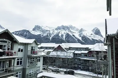 a group of buildings with mountains in the background at Rocky Mountain Retreat-Mountain View! in Canmore