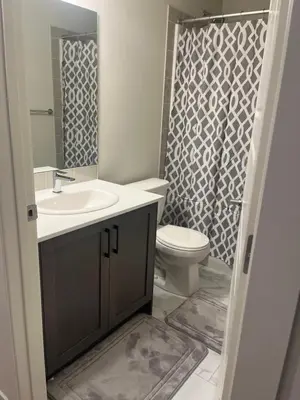 a bathroom with a sink and a toilet and a shower at Livingston Calgary Lovely space in Calgary