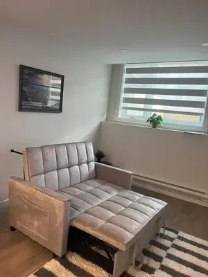 a living room with a couch and two windows at Livingston Calgary Lovely space in Calgary
