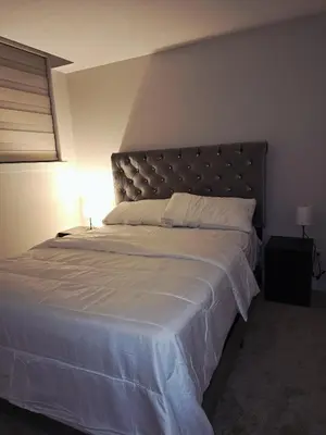 a bedroom with a large bed with a large headboard at Livingston Calgary Lovely space in Calgary