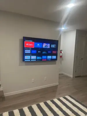 a flat screen tv on a wall in a room at Livingston Calgary Lovely space in Calgary