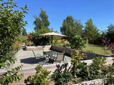 a table and chairs with an umbrella in a garden at \u6e29\u54e5\u534e\u5217\u6cbb\u6587\u522b\u588542 in Richmond