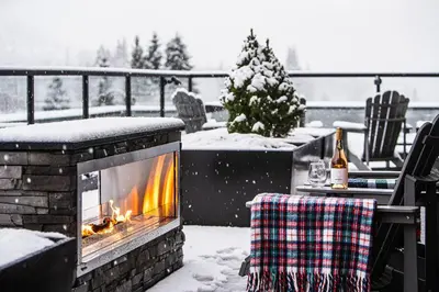 a fireplace on a patio in the snow at Wooley Terrace by Revelstoke Vacations in Revelstoke