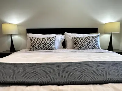 a bedroom with a large bed with two lamps at 2BD cozy guest suite in West Vancouver! in West Vancouver