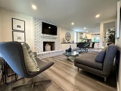 a living room with two chairs and a fireplace at 2BD cozy guest suite in West Vancouver! in West Vancouver