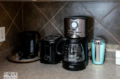 a coffeemaker and a coffee maker on a counter at The Breakfast Club Suite - KingBed& AC - Patio - UG Park in Edmonton