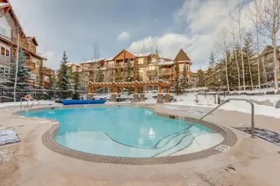 a pool at a resort in the snow at Peaceful 1BR Condo with Hot Tub and Pool in Canmore