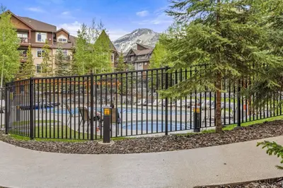 a black fence with a parking meter next to a street at Peaceful 1BR Condo with Hot Tub and Pool in Canmore