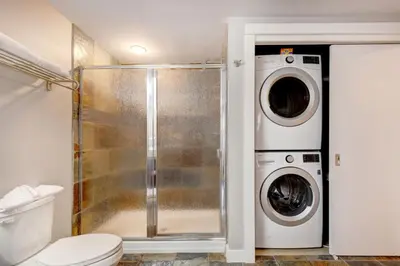 a bathroom with a toilet and a washer and dryer at Silver Creek 2BR Bliss Hot Tub Access MTN Views in Canmore