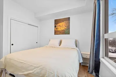 a bedroom with a bed and a window at Luxurious Large 3 Bedroom Loft Saskatchewan Drive in Edmonton