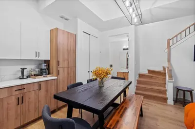 a kitchen and dining room with a wooden table and chairs at Luxurious Large 3 Bedroom Loft Saskatchewan Drive in Edmonton