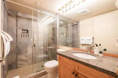 a bathroom with a shower and a toilet and a sink at Wildwood Lodge 113 by Outpost Whistler in Whistler