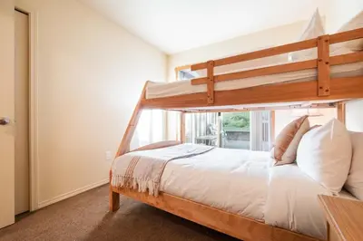 a bedroom with a bunk bed and a window at Wildwood Lodge 113 by Outpost Whistler in Whistler