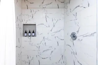 a white bathroom with a shower with white marble at Cozy Quiet Suite - 2 Bedrooms and 2 Full Bathrooms in Calgary