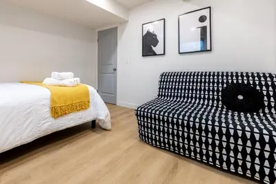 a bedroom with a bed and a couch at Cozy Quiet Suite - 2 Bedrooms and 2 Full Bathrooms in Calgary