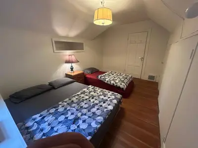 a small bedroom with two beds and a lamp at Vancouver Budget Guesthouse - Free Parking, Fast WiFi, Near Airport & Downtown in Vancouver