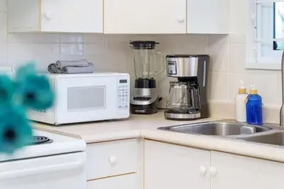 a kitchen counter with a microwave and a sink at NEW Roomy 3BR Family Suite. 5 min to Skytrain. in Vancouver