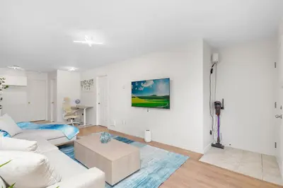 a white living room with a couch and a table at NEW Roomy 3BR Family Suite. 5 min to Skytrain. in Vancouver