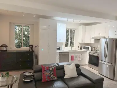 a living room with a black leather couch in a kitchen at Ridge Pointe Retreat Your Victoria Hideaway in Colwood