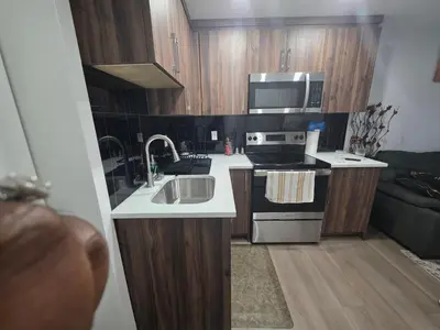 a small kitchen with a sink and a microwave at YYC Cozy Suites in Calgary
