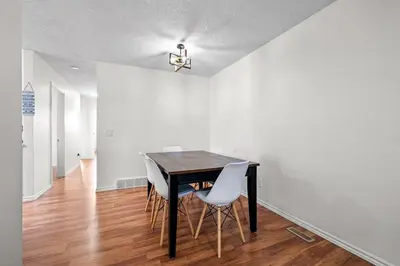 a dining room with a table and white walls at Quiet & Modern Calgary Stay, Prime Location Near YYC, Free Parking in Calgary