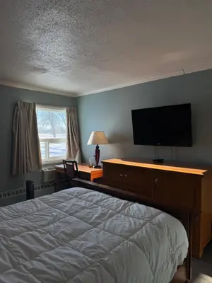 a bedroom with a bed and a flat screen tv at Country Road Motor Inn