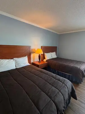 a hotel room with two beds and a lamp at Country Road Motor Inn