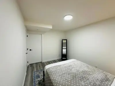 a bedroom with a bed in a room at Brand New cozy apartment bright, modern private 2 bedroom basement! in Calgary