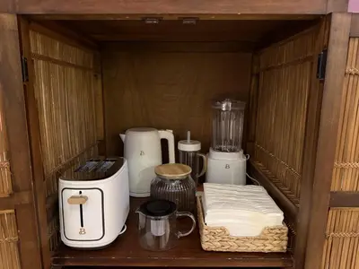 a wooden cabinet filled with appliances on a table at Private 2BR Forest Suite in Bragg Creek with Hot tub, pond, 17 acres of trails in Bragg Creek
