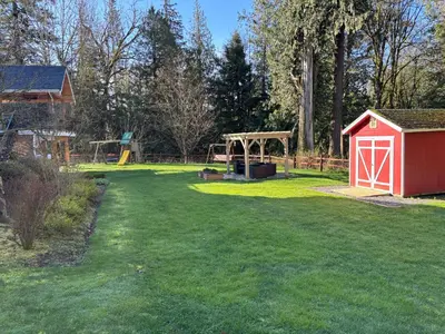 a yard with a red shed and a playground at Sumas Mountain basement suite in Abbotsford